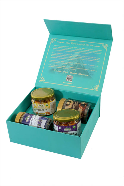 Himalayan Gift Hamper with honey, dry fruits, tea, and ragi cookies in a teal gift box.